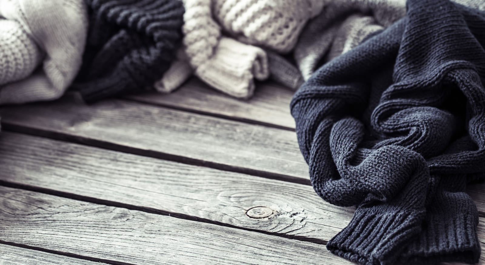 Gestrickter Pullover an einer Holzwand